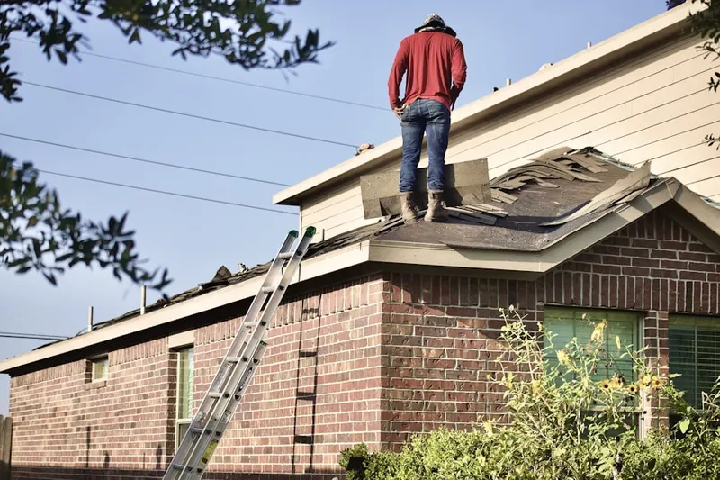Professional roofer working on a residential roof in West Ward